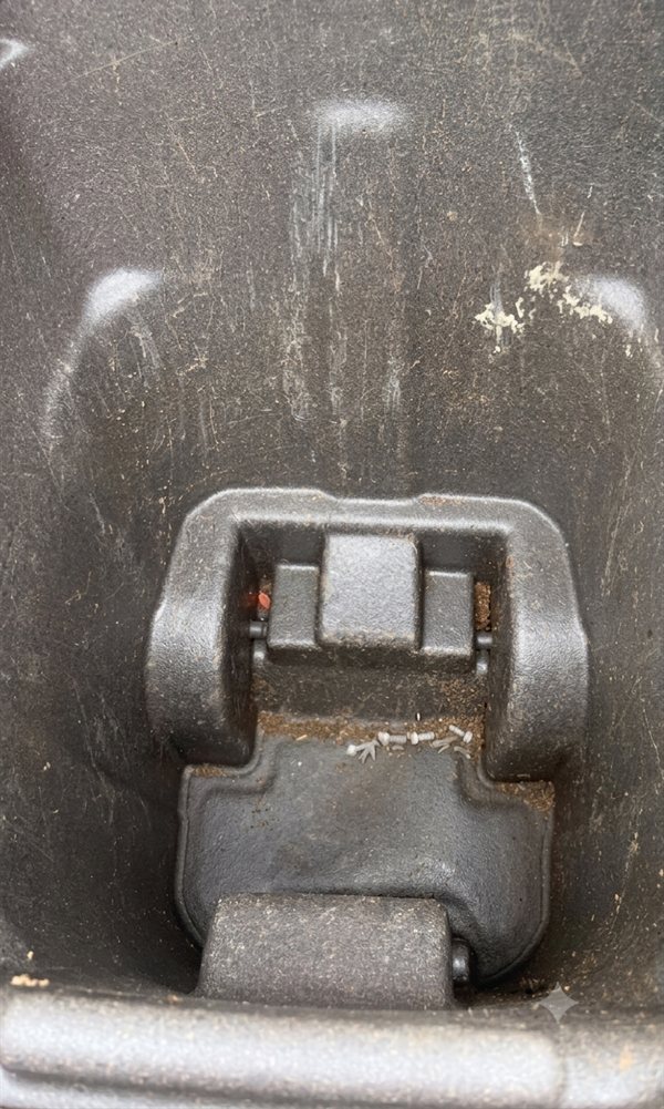 Grimy bin latch and hinge caked with buildup before cleaning